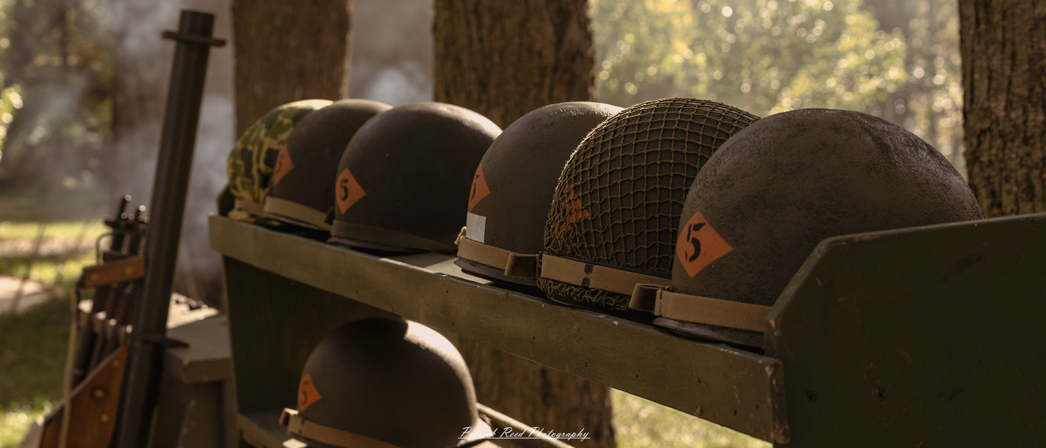 "World War II helmets displayed in a row on a stand, showcasing various styles and designs used by different military forces during the war. Each helmet is positioned neatly, highlighting its unique features, such as camouflage patterns, insignias, and wear marks that tell a story of its use in combat. The backdrop is a neutral color to emphasize the helmets, creating a historical and educational atmosphere that invites viewers to appreciate the craftsmanship and significance of these iconic pieces of military gear."